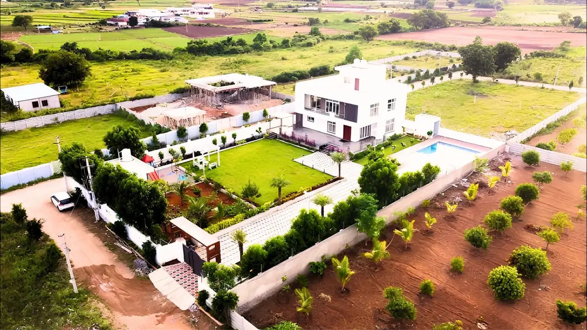 Modern farmhouse with landscaped gardens, green lawns, plantation areas, and sustainable residential development.