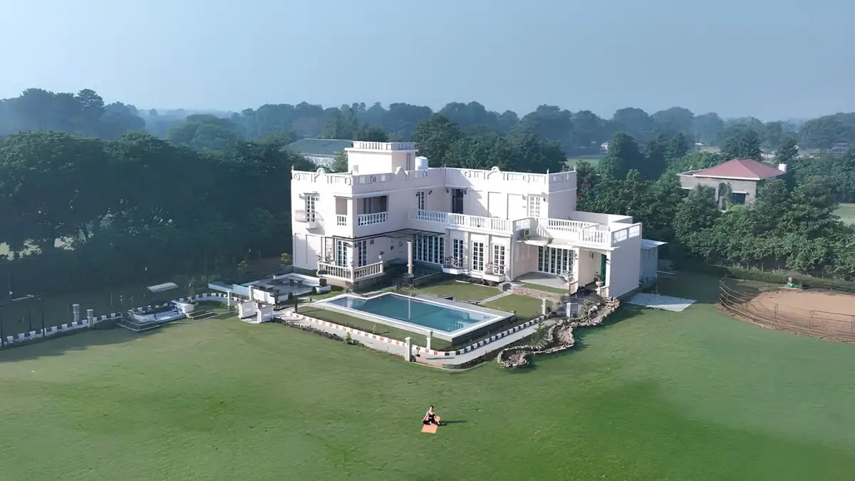 Premium luxury residence surrounded by expansive green lawns, landscaped gardens, water features, and sustainable living spaces.
